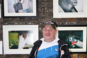 Martin Joyce, IN SIGHT photographer, standing along side two of his photographs at the first IN SIGHT exhibition in Powerscourt Centre. 